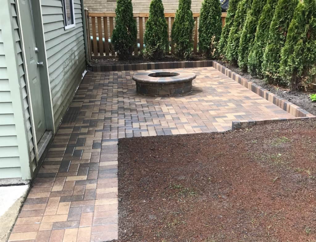 Built-in brick fire pit set into a paver patio in a Chicago-area backyard, R & G Almanza hardscaping