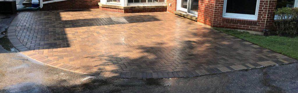 Finished herringbone paver patio, the surface an outdoor kitchen build starts from