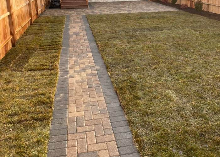 Patio paving and cedar fence installation underway on a Chicago-area residential property