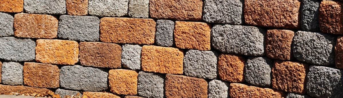 Natural stone masonry retaining wall built along a landscaped slope