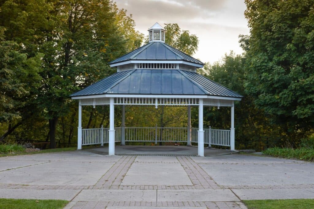 White gazebo with a tiered metal roof, the solid-roof alternative to an open pergola