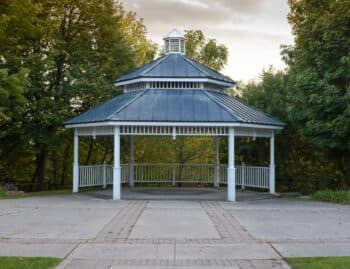 White gazebo with a tiered metal roof, the solid-roof alternative to an open pergola