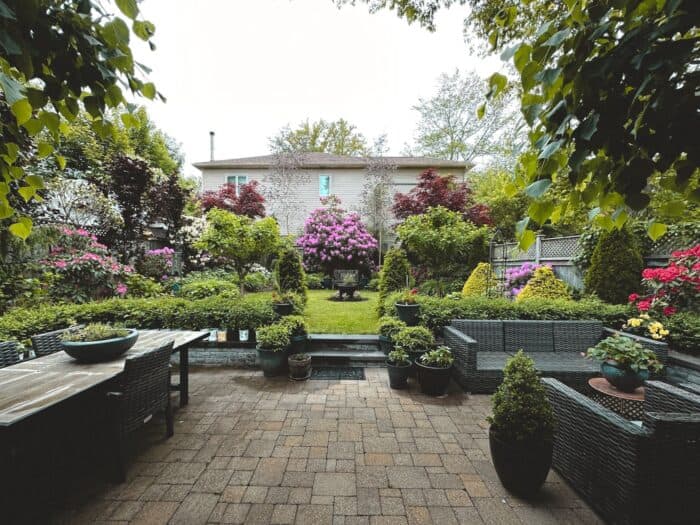 Backyard garden with patio furniture, flower beds and lush plantings, the finished look a Chicago landscape design fee buys