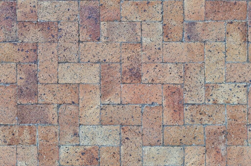 Herringbone-pattern brick pavers set edge to edge, the interlocking style used in paver driveways