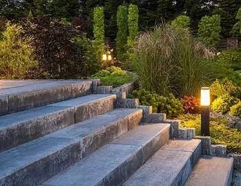 landscaped garden with concrete stairs and decorative illuminati